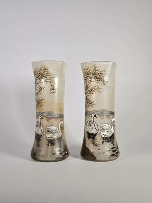 deux vases ornés de cygnes, posés sur une table