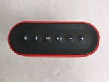 a red and black speaker sitting on a white surface
