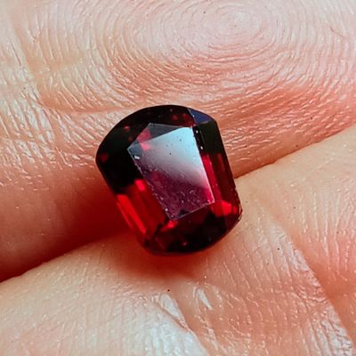 quelqu'un tient un diamant rouge à la main, passé à un doigt