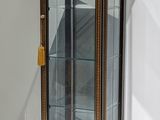 a glass display case with a clock inside of it