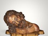 an image of a statue of a man laying on top of a wooden base