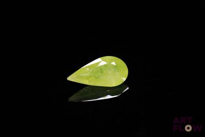 un gros plan d'un quartz vert posé sur une surface noire