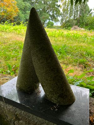 a stone sculpture of two cones on top of a stone block