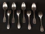 six silver spoons are lined up in a row on a black surface
