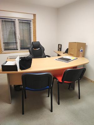une photo d'un bureau avec un bureau et des chaises