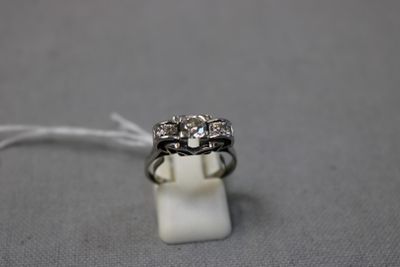 un gros plan d'une bague en diamant posée sur un bloc de marbre blanc