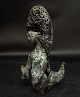 bronze sculpture of a woman sitting on the ground with her hands on her knees
