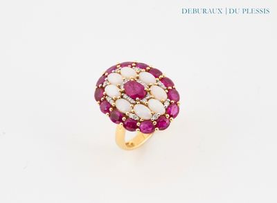 un gros plan d'une bague rose et blanche posée sur une surface blanche