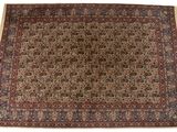 un tapis persan antique avec un motif floral sur fond blanc