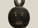 an image of a wooden mask with horns on a black stand
