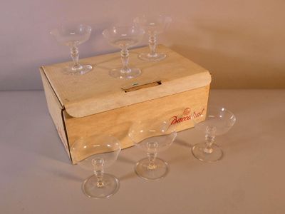 plusieurs verres à vin vides dans une caisse en bois posée sur une table