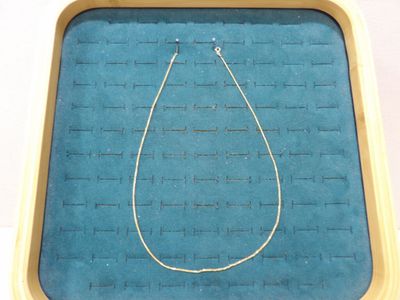 un collier exposé dans une boîte posée sur une table