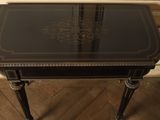 an image of a black table with a glass top on a wooden floor