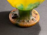 a yellow and green vase sitting on top of a table