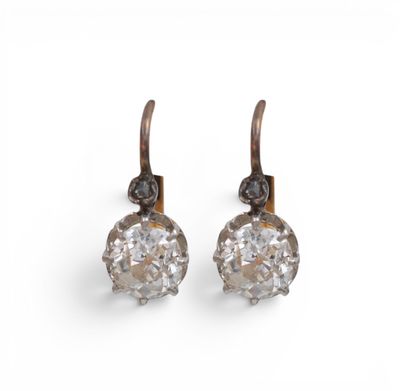 une image d'une paire de boucles d'oreilles en diamant sur fond blanc