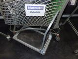 un caddie sur lequel est accrochée une affiche, dans un magasin