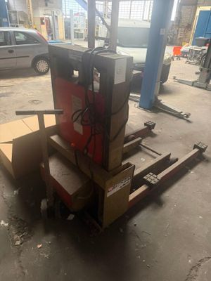 a close up of a forklift with boxes on it in a garage