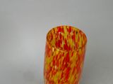 a red and yellow vase sitting on a white surface