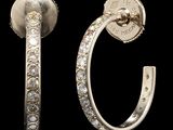 une paire de boucles d'oreilles créoles en diamant sur fond noir, avec un fond noir