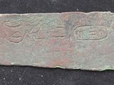 a close up of a piece of metal with writing on it