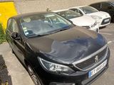 a black car parked in a parking lot next to other cars