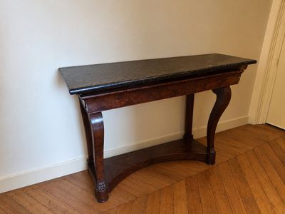 une table en bois avec un plateau noir dans une pièce