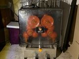 oranges in a plastic container sitting on a metal stand