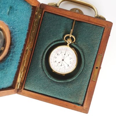 une petite boîte en bois contenant une montre de poche