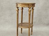 une table d'appoint dorée surmontée d'une étagère