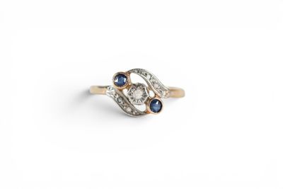 a close up of a diamond and sapphire ring on a white background