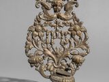 un objet en métal richement décoré, orné d'un oiseau et de fleurs