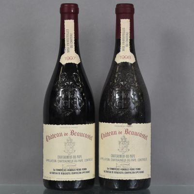 deux bouteilles de vin rouge sont posées sur une table en verre