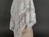 a close up of a white wedding shawl on a mannequin head