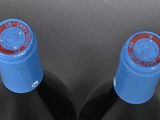 two bottles of wine sitting next to each other on a table