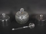 three glass jars and a spoon on a black surface