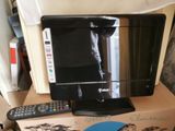 un téléviseur posé sur un carton, avec une télécommande