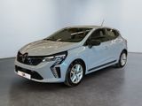 Une voiture argentée est garée dans une pièce aux murs blancs.