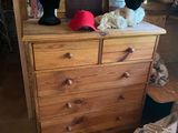 une commode en bois sur laquelle sont posés trois chapeaux