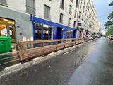 a blue train on the tracks next to a building