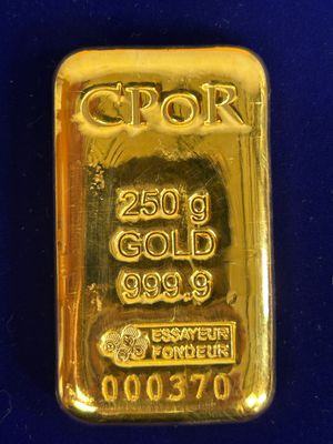 un gros plan d'un lingot d'or sur un fond bleu