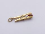 a small gold pliers with a red bead on it