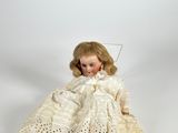 an image of a doll with a white dress and a white hat