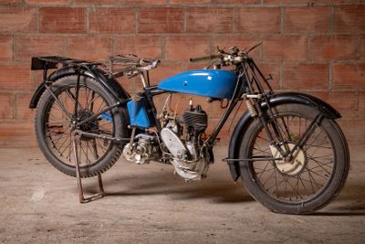 a blue motorcycle that is parked in front of a brick wall