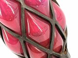 a close up of a pink glass vase with a metal handle