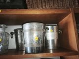 a shelf that has a bunch of silver buckets on it