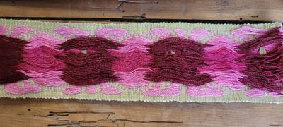 un gros plan sur un ruban rose et marron posé sur une table en bois