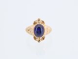 une bague en or avec une pierre bleue au centre
