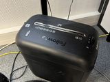 a black paper shredder sitting on the floor next to a microphone