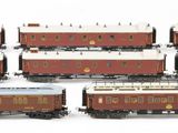 six toy trains are lined up in a row on a white surface