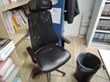 a black office chair in front of a bookshelf